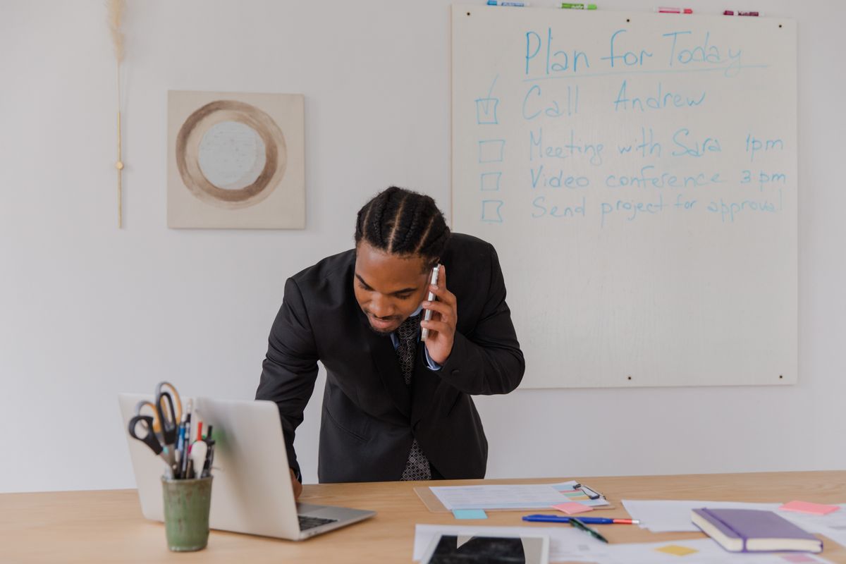 Business owner following up with a customer on a call while working on a laptop